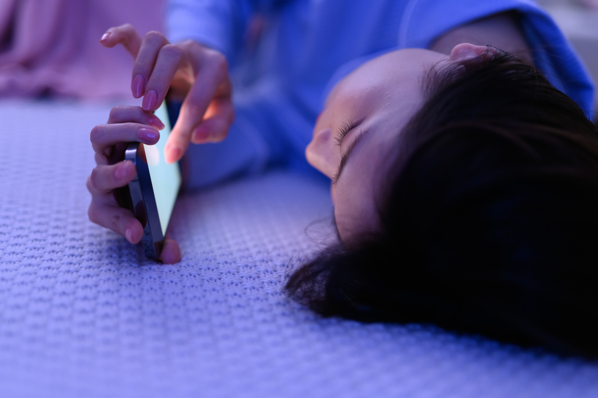 就寝前にスマホを至近距離で見ている女性のイラスト｜朝起きられない原因になる「ブルーライトの影響」を堺そらはねメンタルクリニックが解説